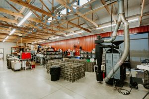 Interior view of a spacious construction workspace featuring shelving units, equipment, and storage containers, showcasing the operational environment of Knapp Builders.